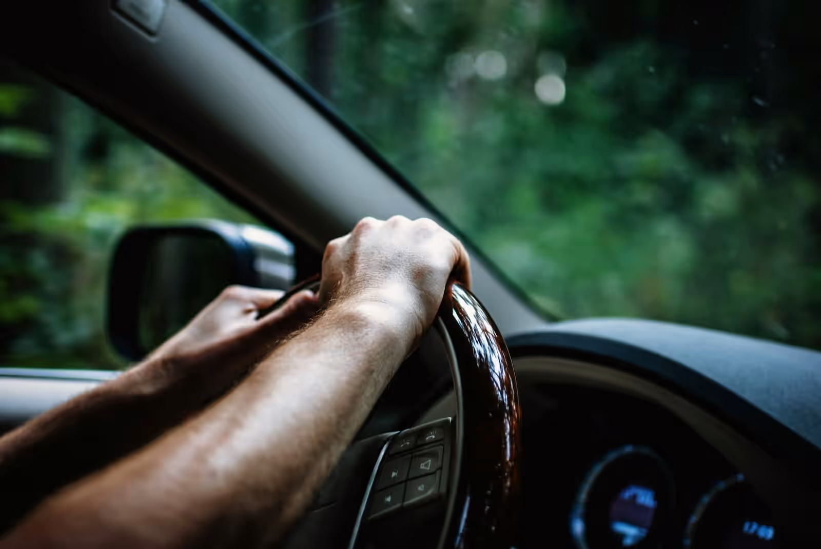 A driver's hands on the steering wheel of a clean cab