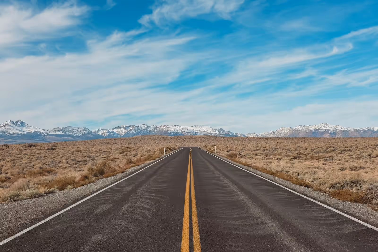 An open highway stretching to the horizon under a clear sky